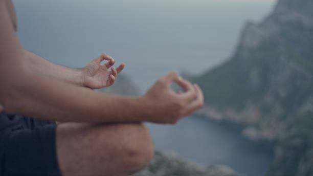istock Man meditation. Rocky coastline. Close up on hands 1097435416