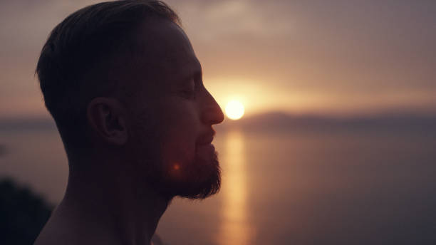 istock Man meditation. Rocky coastline sunset 1097435472