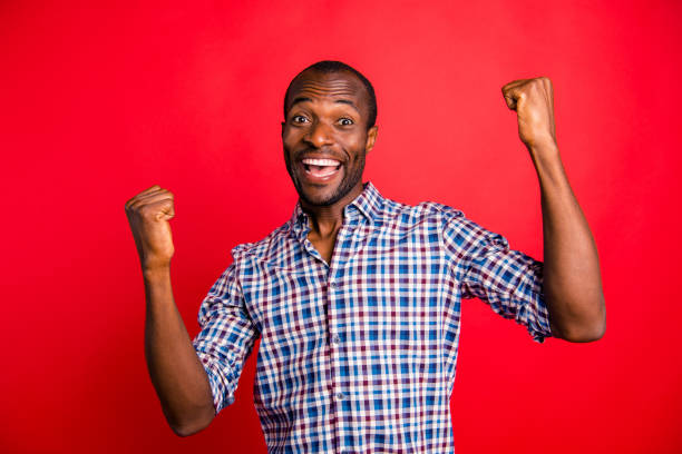 istock Portrait of nice handsome cheerful cheery glad optimistic guy wearing checked shirt showing winning gesture holding fists isolated over bright vivid shine red background 1097435562
