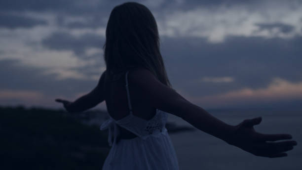 istock Woman meditating on rocky coastline. Open arms 1097435736