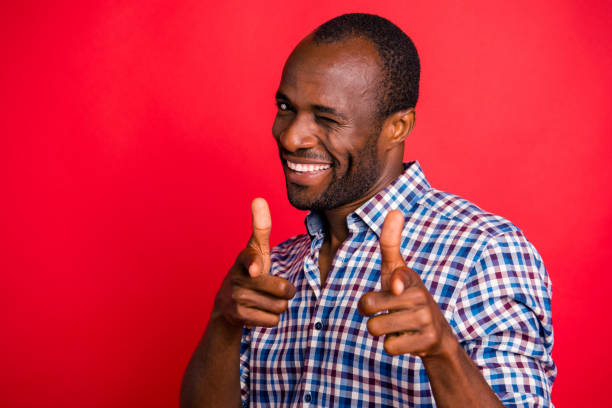 Portrait of nice handsome attractive cheerful positive guy wearing checked shirt pointing at you two forefingers inviting to party isolated over bright vivid shine red background Portrait of nice handsome attractive cheerful positive guy wearing checked shirt pointing at you two forefingers inviting to party isolated over bright vivid shine red background blinking stock pictures, royalty-free photos & images