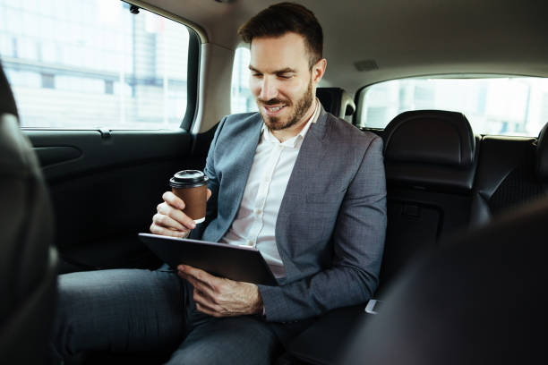 istock Businessman in a car holding digital tablet and smiling 1097436314
