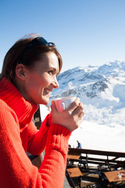 istock woman drinking a hot drink in the snow 1097442526