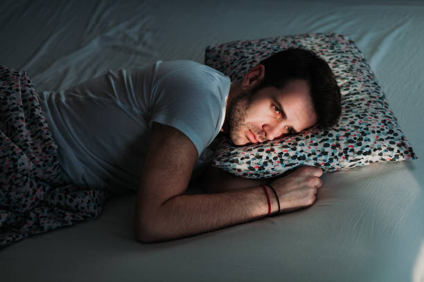istock Young depressed man in pain on the bed 1097443538