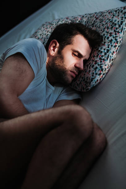 istock Young depressed man in pain on the bed 1097443554