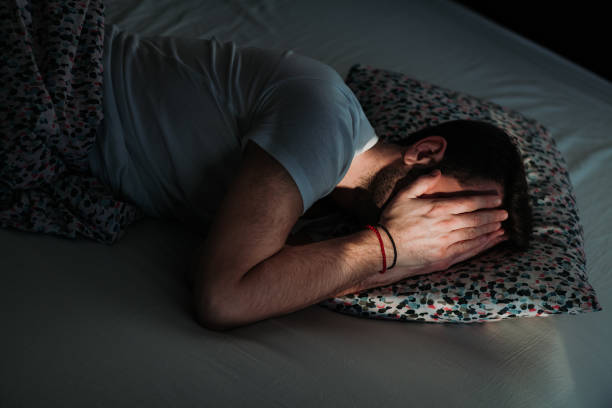 istock Young depressed man in pain on the bed 1097443558