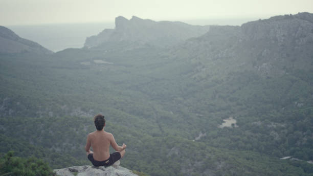istock Man meditation. Rocky coastline 1097443944