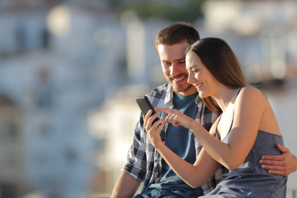 istock Happy couple browsing phone content in a town outskirts 1097446776
