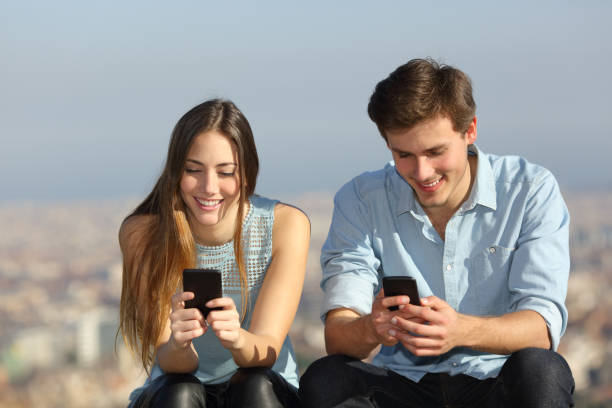 istock Happy couple using their smart phones outside 1097446796