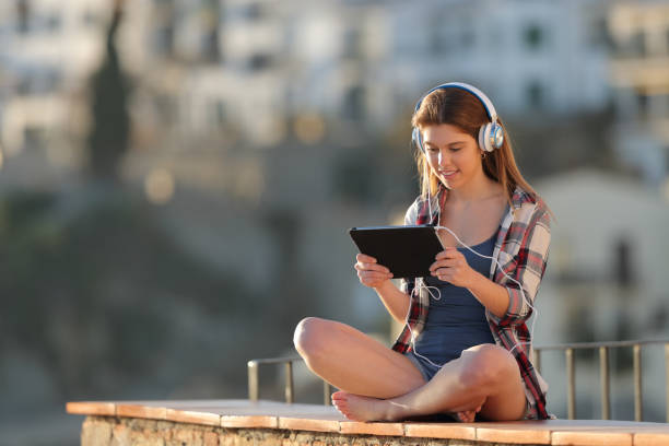 istock Teenager listening and watching tablet online content 1097447008
