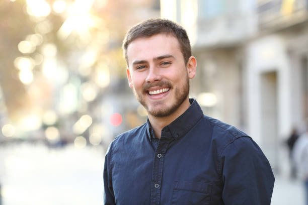 istock Happy man smiling at camera in a street 1097447200