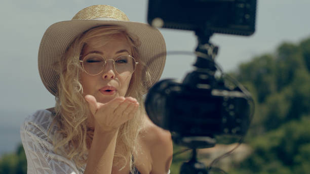 istock Female vlogger on vacation. Blowing a kiss to camera 1097452160