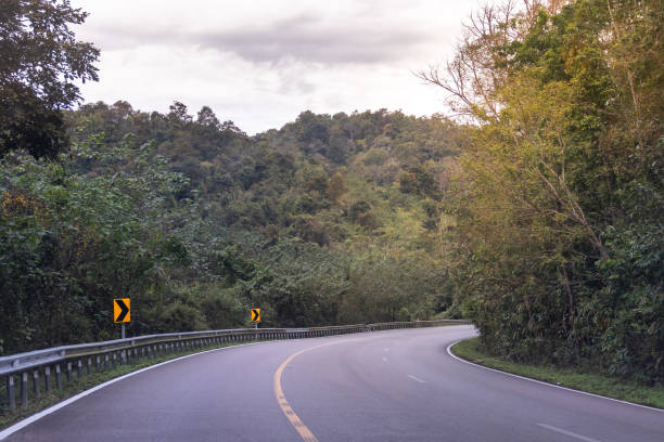 istock Country highway curved in green forest through the mountains 1097452526