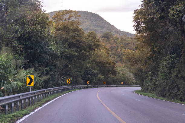 istock Country highway curved in green forest through the mountains 1097452546
