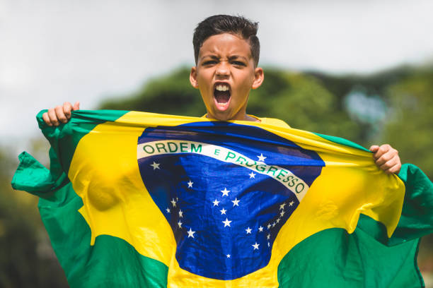 Soccer player child holding brazilian flag