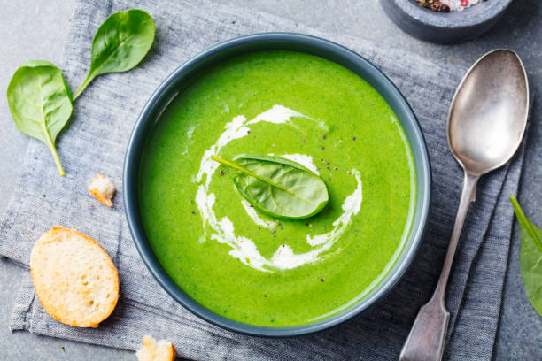 Spinach soup with cream in a bowl. Top view. stock photo
