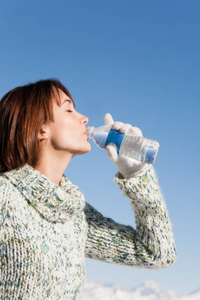 woman drinking water in the snowy mountains