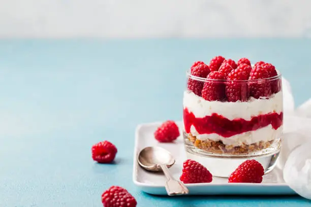Photo of Raspberry dessert, cheesecake, trifle, mouse in a glass. Copy space