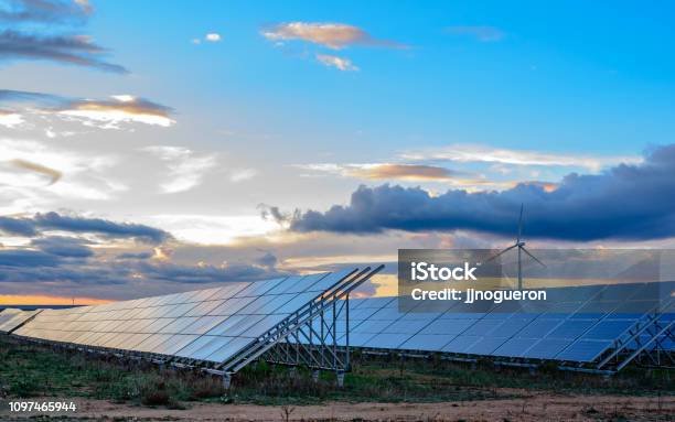 Photovoltaic And Wind Plant At Sunset Stock Photo - Download Image Now - Solar Energy, Sun, Solar Panel