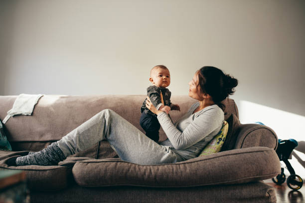 istock Woman sitting on couch with her baby 1097469210