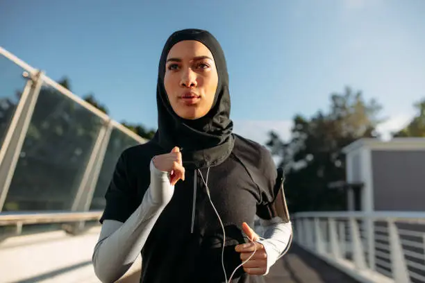 Photo of Healthy sporty woman in hijab jogging
