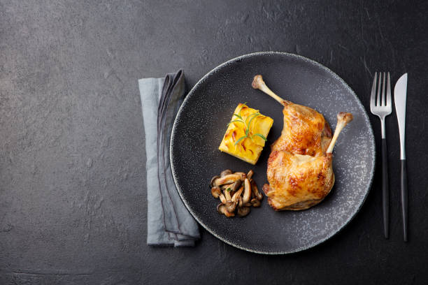 istock Duck legs confit with potato gratin and mushroom sauce. Restaurant serving. Copy space. Top view. 1097469476