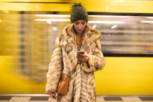 istock Young woman at a train station texting on a mobile phone 1097470218