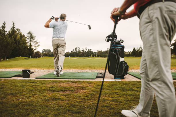 golfista teeing się na driving range - golf golf swing men professional sport zdjęcia i obrazy z banku zdjęć