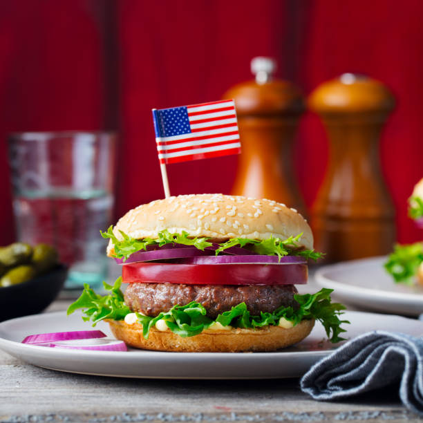 Burger on a plate with American flag. Wooden background.