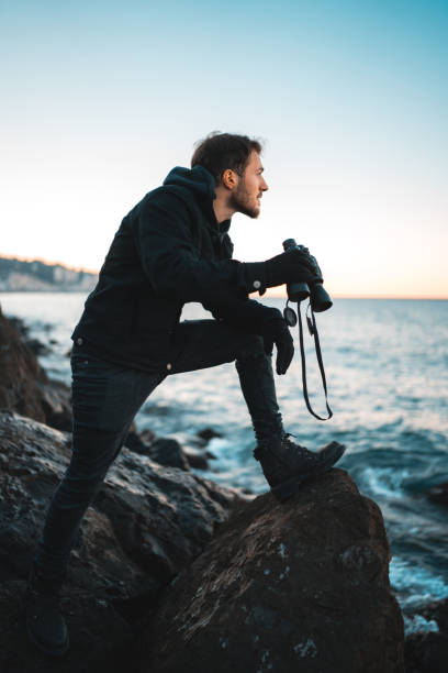 istock Man on sea coast with binoculars in hands 1097474406