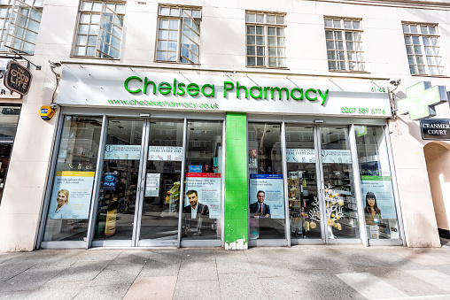 London, UK - June 24, 2018: Neighborhood borough of Chelsea street and exterior entrance to green Pharmacy medicine building and sidewalk