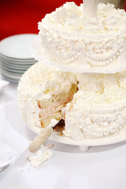 istock A beautiful white two-layer wedding cake with a cut piece. 1097484274