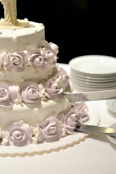 istock Newlyweds cut a beautiful white wedding cake. 1097484508