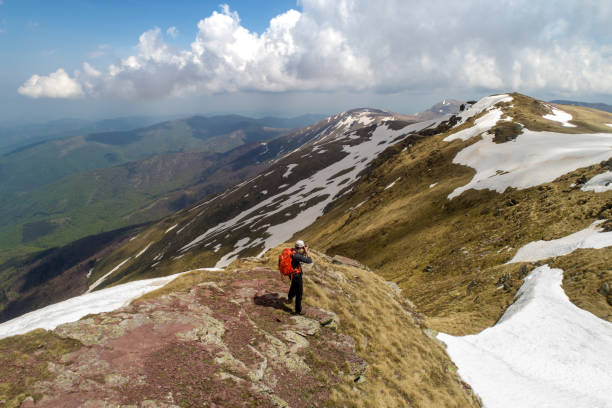 istock Young man taking photo on top of mountain while hiking 1097484882