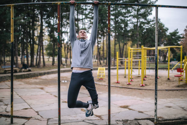 adaptacyjny sportowiec robi podbródki na zewnątrz baru - chin ups audio zdjęcia i obrazy z banku zdjęć