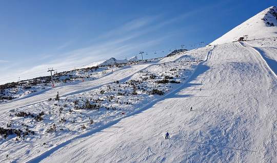 Skiers on ski slope in High Tatras mountains aerial.