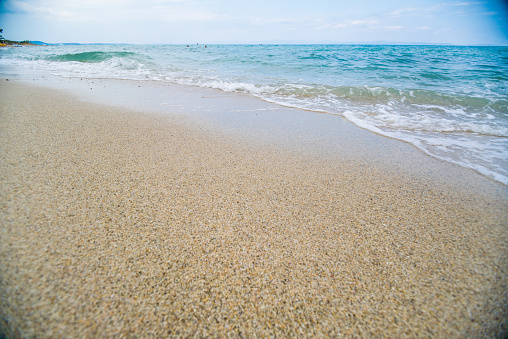 Landscape of a sand beach with turquoise clear water  foam and waves