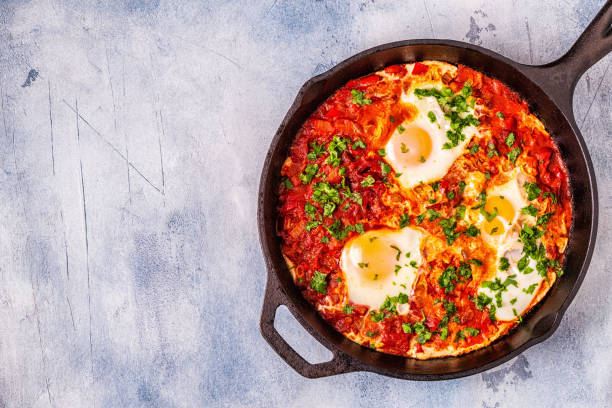 Shakshuka in a Frying Pan Shakshuka in a Frying Pan. Eggs Poached in Spicy Tomato Pepper Sauce. libyan culture stock pictures, royalty-free photos & images