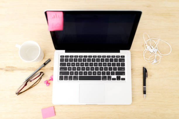 istock Top view office desk with open laptop, smartphone, mug, glasses and office stuff 1097490602