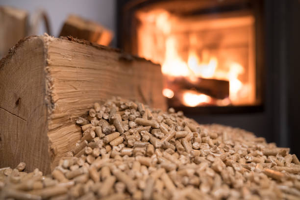 Wood stove heating with in foreground wood pellets Wood stove heating with in foreground wood pellets - economical heating system concept stove stock pictures, royalty-free photos & images
