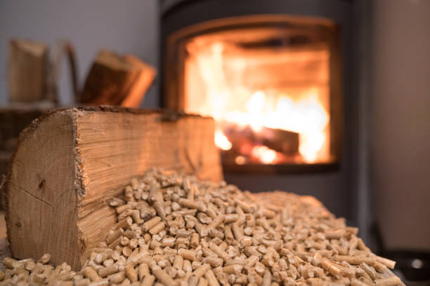 Wood stove heating with in foreground wood pellets Wood stove heating with in foreground wood pellets - economical heating system concept granule photos stock pictures, royalty-free photos & images