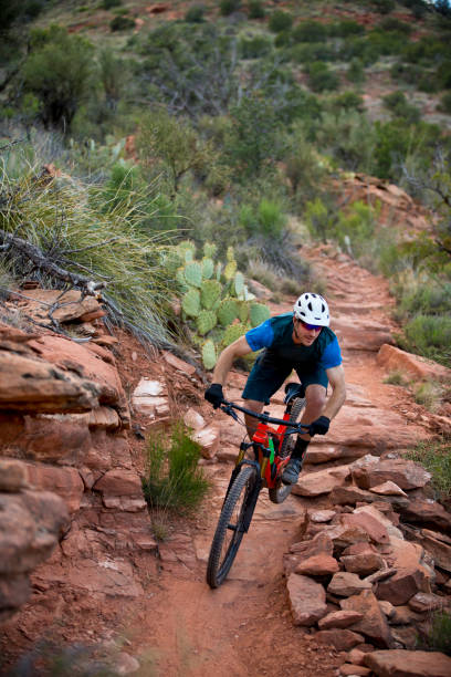 Sedona Mountain Bike Ride A man rides down a popular trail in Sedona, Arizona, USA. He is riding an enduro-style mountain bike and wearing a bicycle helmet. sedona photos stock pictures, royalty-free photos & images