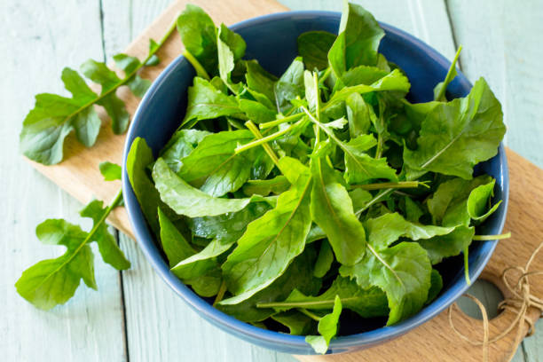 istock Fresh salad arugula leaves on rustic a kitchen wooden table. 1097495432