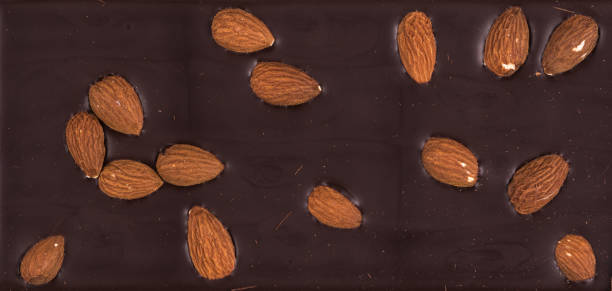 dark chocolate background with almond nuts dark chocolate background with nuts almond slivers stock pictures, royalty-free photos & images