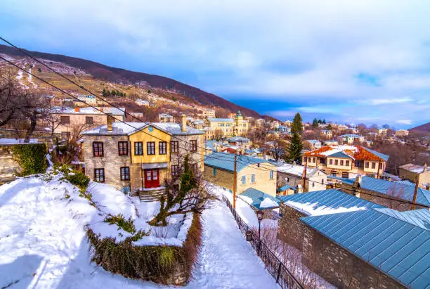 Photo of View of traditional stone buildings and streets with snow at the famous village of Nymfaio near Florina, Greece.