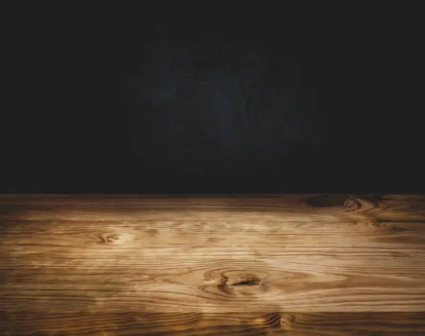 Photo of Empty wood table top counter on dark wall background