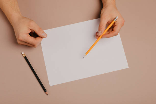 istock Hands writing on paper blank a4 size on grey background. 1097499156