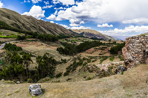 The ruins of an ancient Inca temple at the foot of the green hills on the outskirts of Cusco.