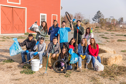 High quality stock photos of high school teens engaged in community service, picking up trash and cleaning up a local river and park.