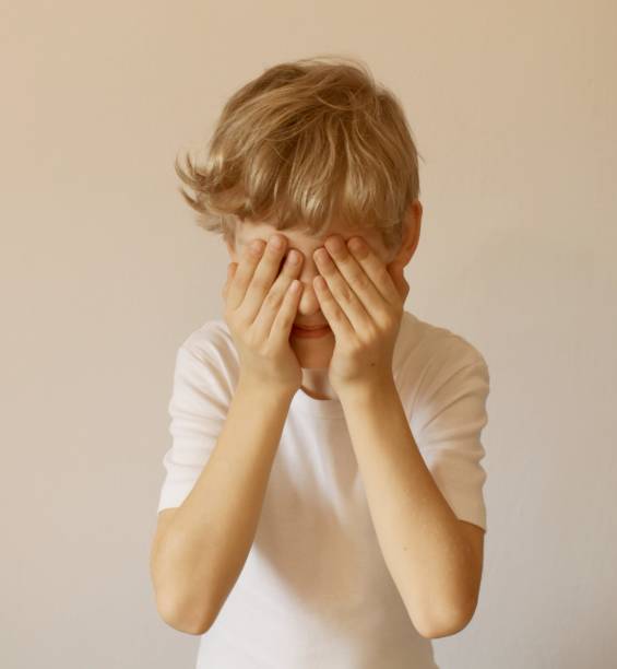 istock Eyes closed palms. I see nothing. The boy closed his eyes with his palms. Light background. 1097504702